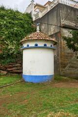 cylindrical cement pigeon coop with a red tile roof