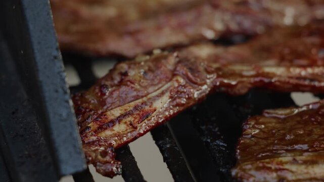During the sunset, Kalbi meat sizzled on the gas grill in the front yard, the marinated beef caramelizing to perfection, its aroma mingling with the evening breeze, creating a mouthwatering scene.