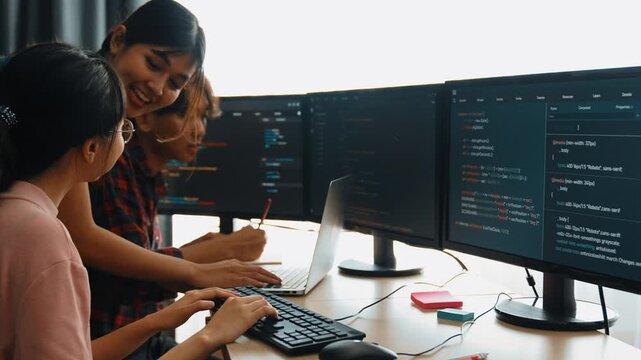 Slow motion back end software developer engineer for computer programming working together on debugging writing computing code, solving complex algorithms display on monitor in office. Burgeoning