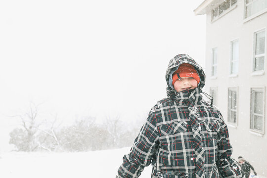 Boy standing in the snow on foggy day at Mount Buller