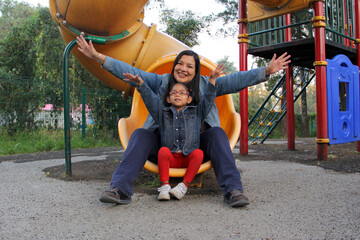 Latin mom plays with her 4-year-old brunette daughter in the park games, they spend quality time together and celebrate Mother's Day