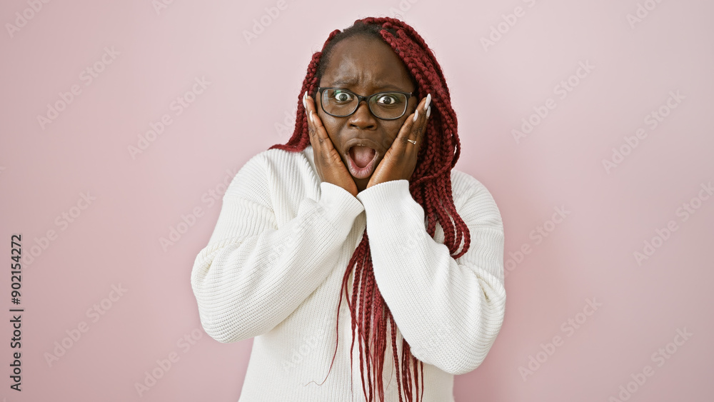 Sticker shocked african american woman with braids wearing glasses over a pink background.