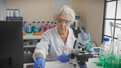 A senior woman scientist examines samples with a microscope in a laboratory setting.