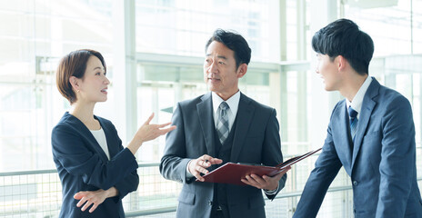 オフィスで立ち話をするビジネスパーソン