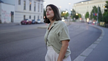 Young beautiful hispanic woman looking around waiting for someone in the streets at night