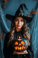 A woman dressed as a witch without hat, holding a Halloween pumpkin with candles in clean dark blue background