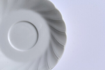 Close-up of a white plate with spiralled edges on a white background