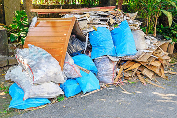 A pile of blue and gray bags and pillows sit on the ground