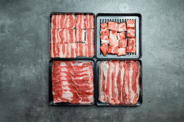 A close up of four different cuts of meat, including a slab of beef