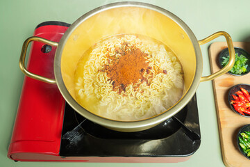 A pot of instant noodles with a red lid on top