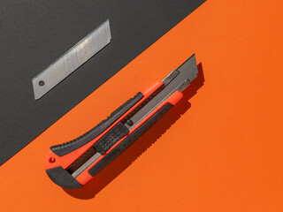 Utility Knife and Blade on Orange and Black Surface, Cutting Tool for DIY Projects and Office Tasks