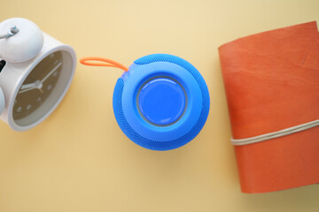 smart speaker clock and notebook on table 