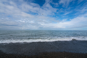 Black Sea on the Sochi coast and a pebble beach on a sunny day with clouds, Sochi, Krasnodar Territory, Russia