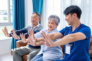 Obraz premium Senior Asian couple get medical service visit from male caregiver nurse at home while doing physical therapy to shoulder stretching for muscle pain in health care and pension welfare