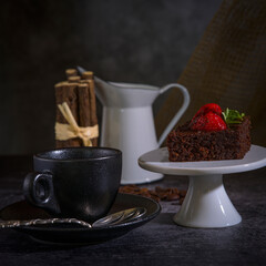 Schokoladenkuchen mit Erdbeeren und einer Tasse Kaffee