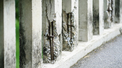 Damaged old reinforced concrete pillars, Cracked concrete surface with visible rusty reinforcement of bridge