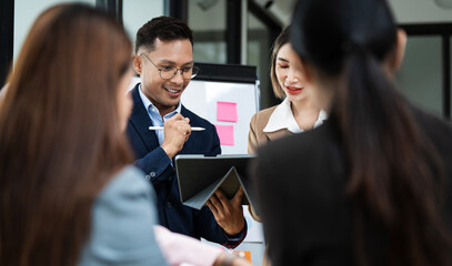 Diverse business team analyzing data and discussing strategies during an office meeting