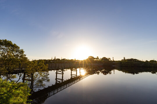 Wooden footbridge leading across Simpsons Creek at Brunswick Heads at sunrise