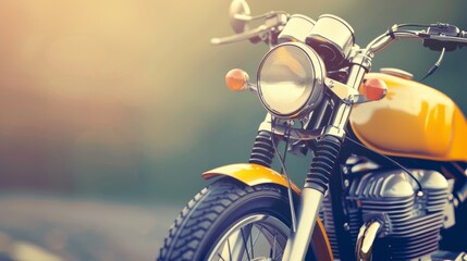 A close-up of a classic motorcycle with a yellow tank, chrome accents, and a sunlit background. The image evokes a sense of adventure and freedom.