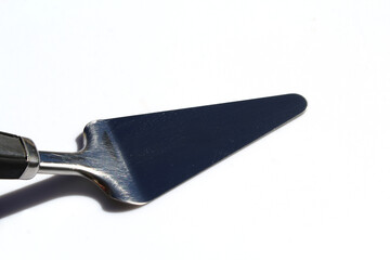 Metal cake server against a white background