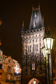 Prague Powder Tower Prasna brana, medieval gothic city gate to the old town of Prague, illuminated at night with a beautiful street lamp, historical sight in Prague, Czech Republic