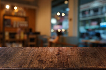 Empty dark wooden table in front of abstract blurred boken bankground of restaurant. Can used for display or montage your products. Mock up for space.