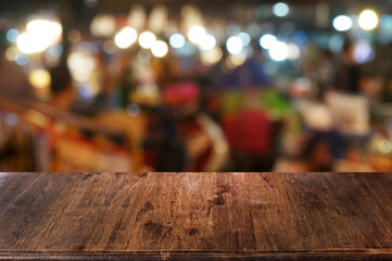Empty dark wooden table in front of abstract blurred boken bankground of restaurant. Can used for display or montage your products. Mock up for space.