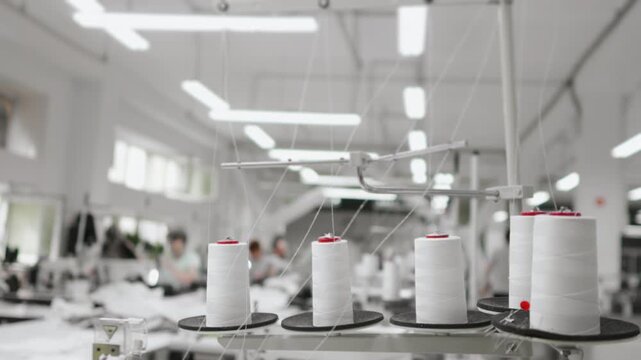 Factory for the production of clothing. Spools of thread in a garment factory. Threads for sewing clothes.