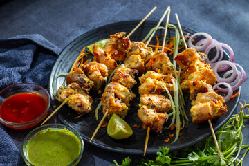 Chicken reshmi kabab or chicken malai kabab, delicious Mughlai cuisine, serve with mint chutney and tomato sauce. selective focus. 