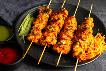 Deliciously Spiced Chicken Tikka Kabab, A Flavourful Grilled Delight with Tangy Marinade and Smoky Charcoal Aroma Serve with Mint and Tomato Chutney. Selective focus. 