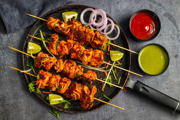Deliciously Spiced Chicken Tikka Kabab, A Flavourful Grilled Delight with Tangy Marinade and Smoky Charcoal Aroma Serve with Mint and Tomato Chutney. Selective focus. 