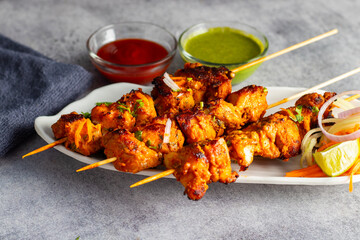 Deliciously Spiced Chicken Tikka Kabab, A Flavourful Grilled Delight with Tangy Marinade and Smoky Charcoal Aroma Serve with Mint and Tomato Chutney. Selective focus. 