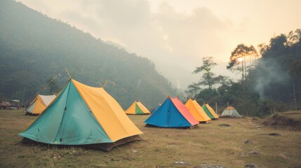 Colorful tents line the campsite, nestled in the hills as the sun sets, creating a serene outdoor atmosphere