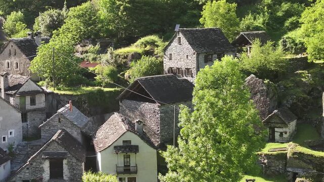 Aerial view of traditionally built houses in the village of Maggiatal Vallemaggia, Tessin, Switzerland. Concept of cultural heritage, architectural beauty, and the charm of rustic village life.