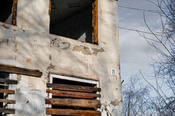 Boarded up windows. An old abandoned wooden house with boarded up windows and a crumbling roof