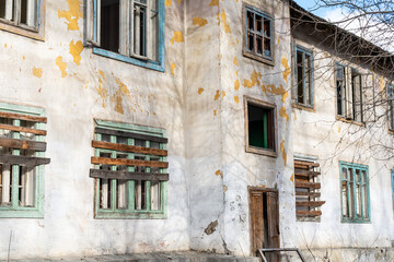 Boarded up windows. An old abandoned wooden house with boarded up windows and a crumbling roof