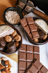 Chocolate chip cookies, chocolate bar and white chocolate, small bowl oatmeal and nuts. International Chocolate Day.