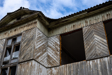 An old cottage with damaged windows and a deteriorating roof