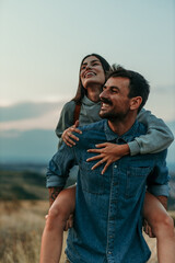 Fototapeta premium Couple having a piggyback ride, happy and smile hug in nature on a travel, adventure and road trip outdoor