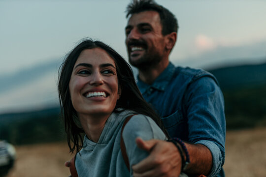 Smiling young couple in love embracing nature. Romantic young man and woman in the countryside.
