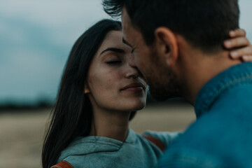 Obraz premium Romantic couple embracing each other and smiling. Close up portrait of a couple in love