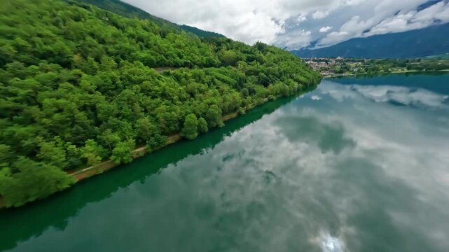 Lago di levico with lush green hills and a peaceful sky reflection, aerial view