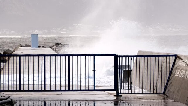 Hermanus New Harbour pier breakwater with dolosse slammed with sea waves, slomo
