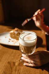 A girl is eating Napoleon cake with a cocktail