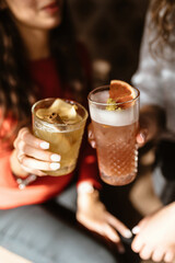 Two cute girls are drinking refreshing cocktails in a beautiful bar