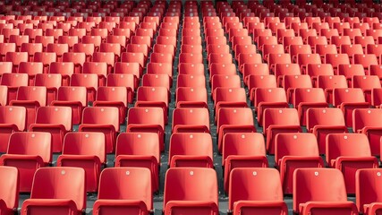 Fototapeta premium Endless rows of empty red plastic seats fill vast stadium arena