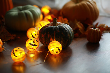 Halloween Decorations with Pumpkins and Jack-o'-Lantern Fairy Lights on Wooden Floor