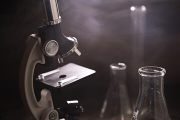 Close-Up of Vintage Microscope and Laboratory Glassware in a Smoky Atmosphere