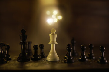 Chess Game Strategy: White King Amidst Black Pieces on Wooden Board
