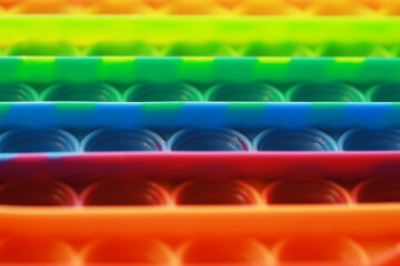 Colorful Close-Up of a Rainbow Pop It Fidget Toy in Rows